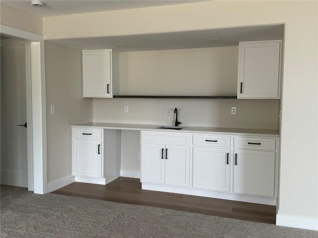 4018 Peridot Dr, Marion, IA 52302 - kitchen featuring a sink, white cabinets, dark colored carpet, baseboards, and light countertops
