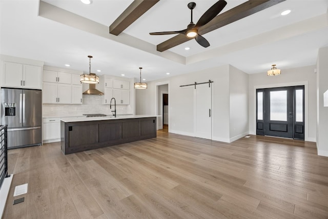 4018 Peridot Dr, Marion, IA 52302 - kitchen featuring stainless steel fridge, a barn door, tasteful backsplash, white cabinets, and beam ceiling