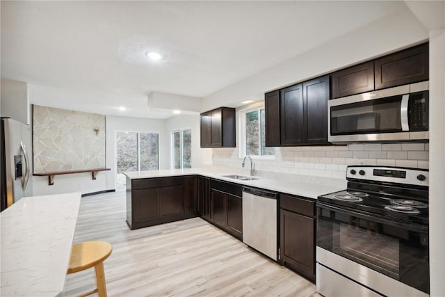 3111 Carroll Dr SE, Cedar Rapids, IA 52403 - kitchen with appliances with stainless steel finishes, a sink, light countertops, backsplash, and dark brown cabinets
