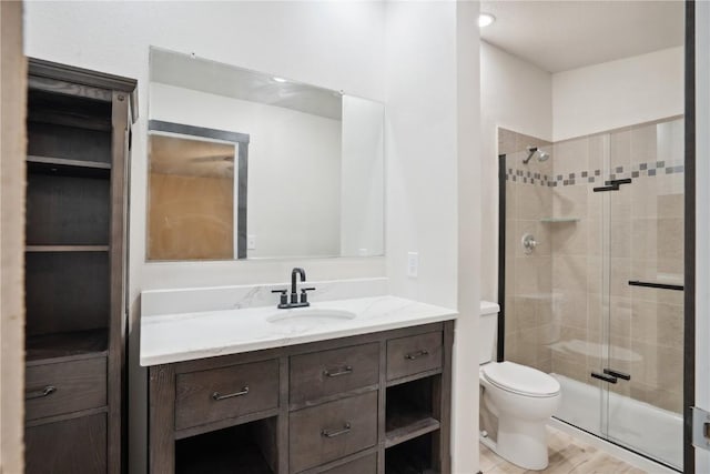 3111 Carroll Dr SE, Cedar Rapids, IA 52403 - bathroom featuring a stall shower, toilet, vanity, and wood finished floors
