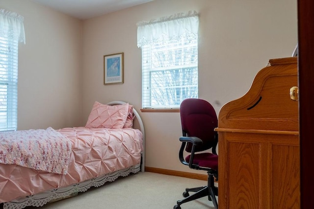 bedroom featuring light colored carpet and baseboards