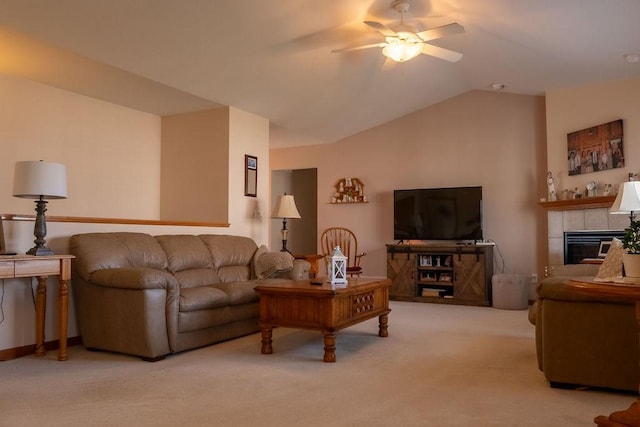 living room with a tile fireplace, light colored carpet, vaulted ceiling, and ceiling fan
