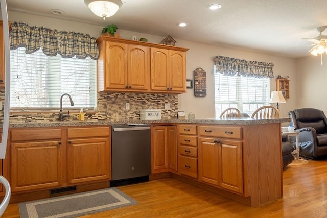 kitchen featuring light wood-type flooring, a peninsula, visible vents, ceiling fan, and dishwasher