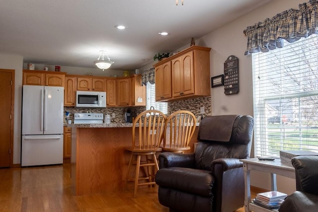 kitchen featuring open floor plan, white appliances, and a healthy amount of sunlight