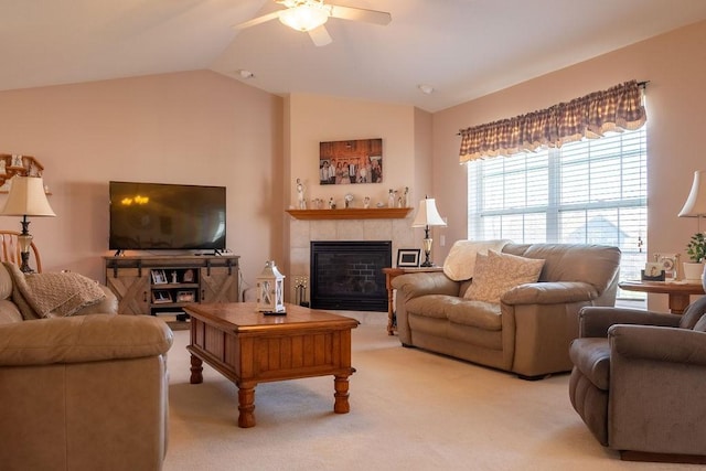 living room featuring a ceiling fan, light colored carpet, vaulted ceiling, and a fireplace