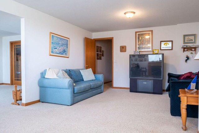 carpeted living area with baseboards
