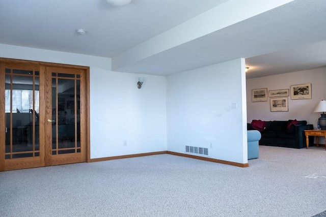 carpeted living room with visible vents and baseboards