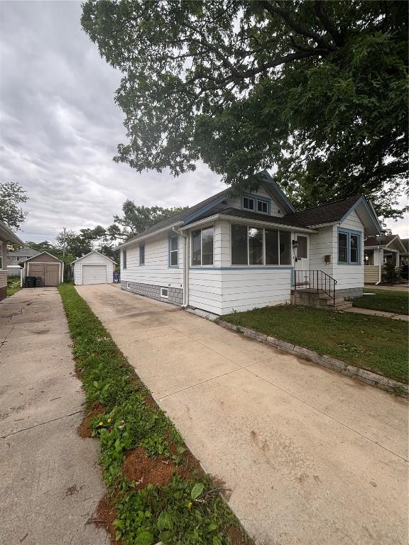 832 Daniels St NE, Cedar Rapids, IA 52402 - bungalow featuring concrete driveway, a detached garage, and an outdoor structure