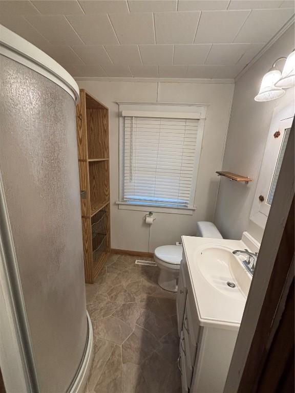 832 Daniels St NE, Cedar Rapids, IA 52402 - bathroom featuring toilet, a shower stall, vanity, and baseboards