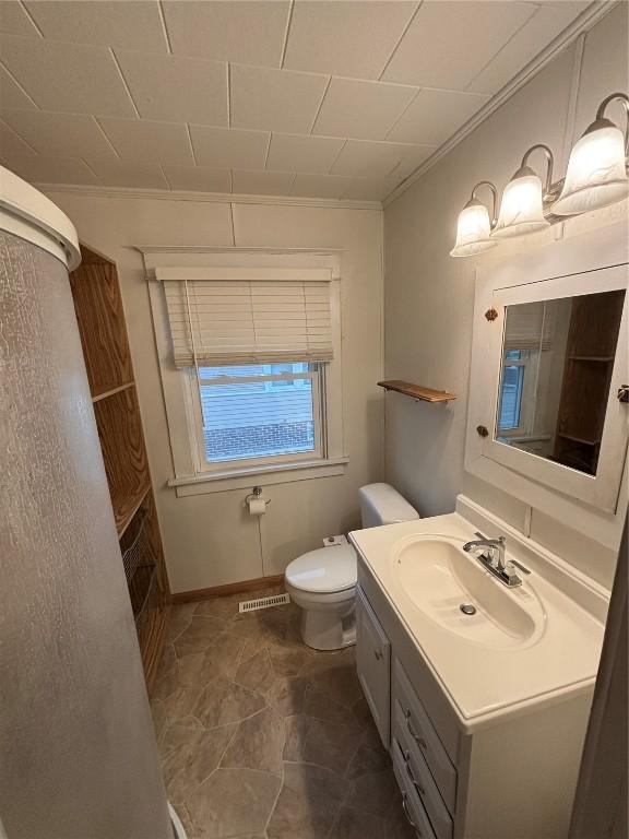 832 Daniels St NE, Cedar Rapids, IA 52402 - bathroom with vanity, toilet, and baseboards