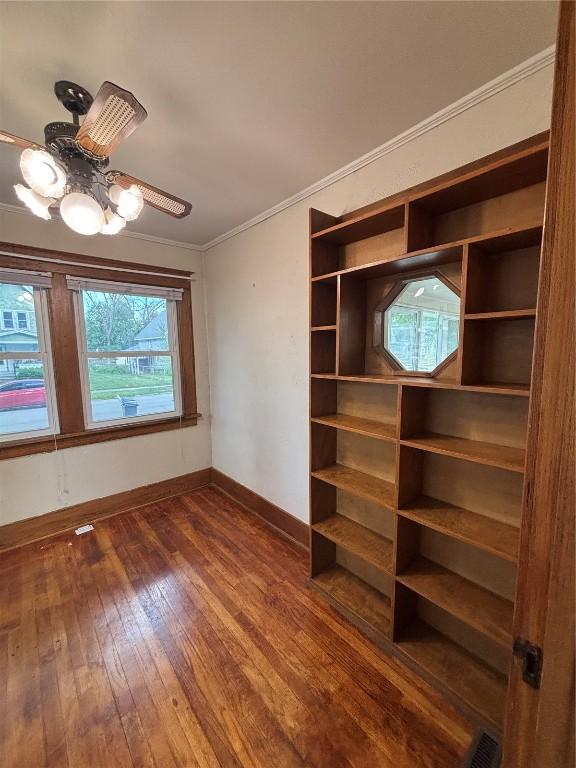832 Daniels St NE, Cedar Rapids, IA 52402 - spare room featuring baseboards, dark wood-style floors, crown molding, and a chandelier