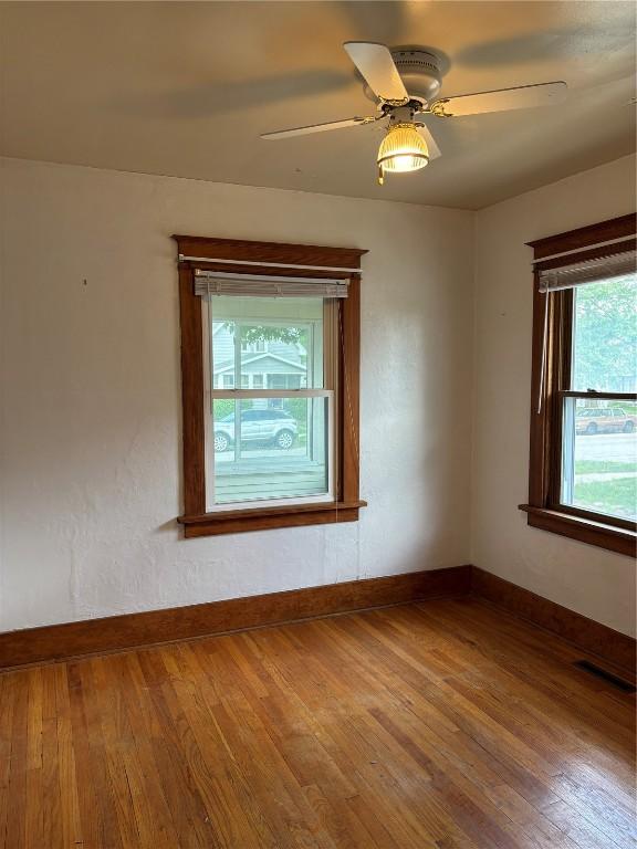 832 Daniels St NE, Cedar Rapids, IA 52402 - spare room featuring wood finished floors, baseboards, and a ceiling fan