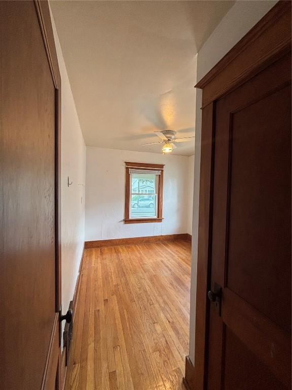 832 Daniels St NE, Cedar Rapids, IA 52402 - spare room featuring light wood-style flooring, a ceiling fan, and baseboards