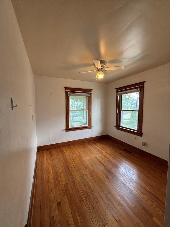 832 Daniels St NE, Cedar Rapids, IA 52402 - spare room featuring plenty of natural light, wood finished floors, ceiling fan, and baseboards