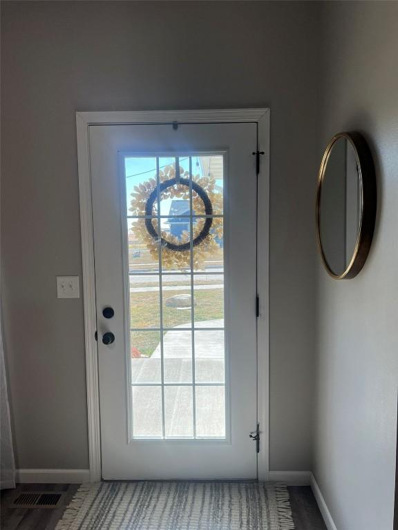 doorway to outside featuring baseboards and visible vents