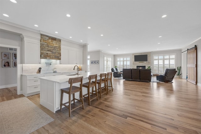 kitchen featuring white cabinets, recessed lighting, and a center island with sink
