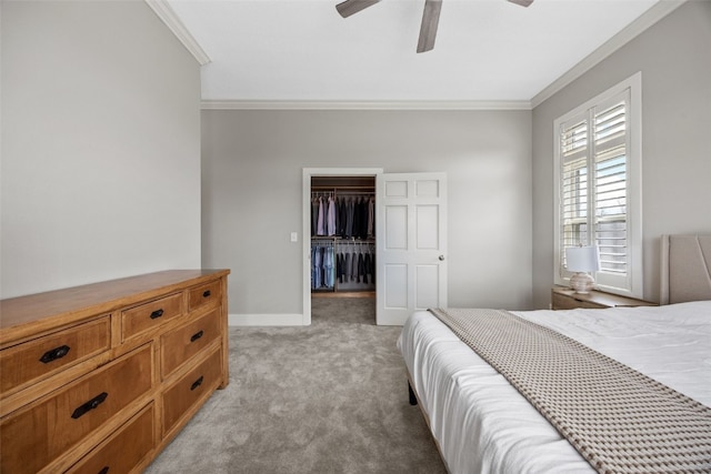 bedroom with baseboards, a spacious closet, ceiling fan, crown molding, and light carpet