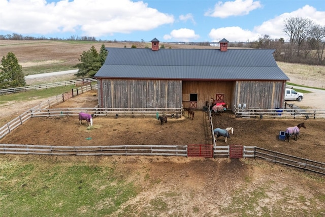 exterior space featuring a rural view, an exterior structure, and an outbuilding