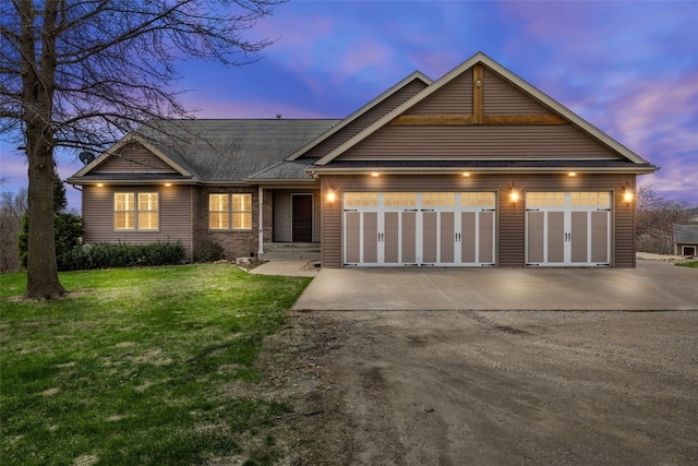 ranch-style home featuring an attached garage, a shingled roof, driveway, and a front yard