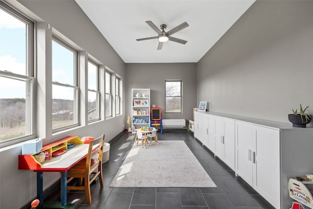 rec room featuring dark tile patterned floors and a ceiling fan