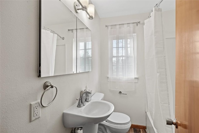 full bathroom featuring toilet, shower / tub combo, and a sink