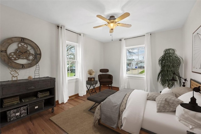 bedroom with a ceiling fan, baseboards, and wood finished floors