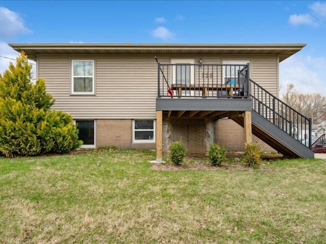 rear view of house with a yard, brick siding, a wooden deck, and stairs