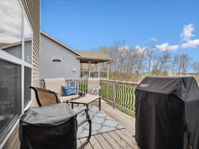 wooden deck with outdoor lounge area and area for grilling