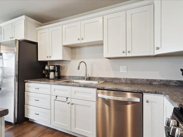 kitchen featuring dark wood-type flooring, a sink, white cabinetry, and stainless steel appliances