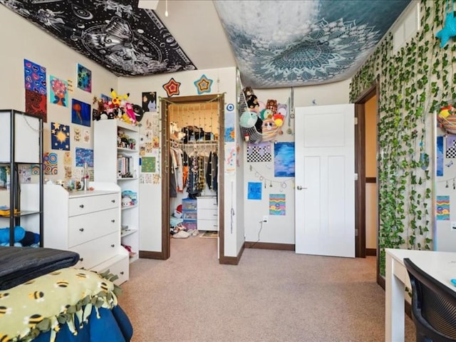 carpeted bedroom featuring a closet, baseboards, and a walk in closet