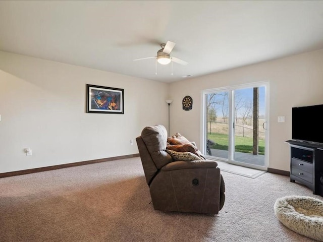 living room featuring carpet, baseboards, and ceiling fan