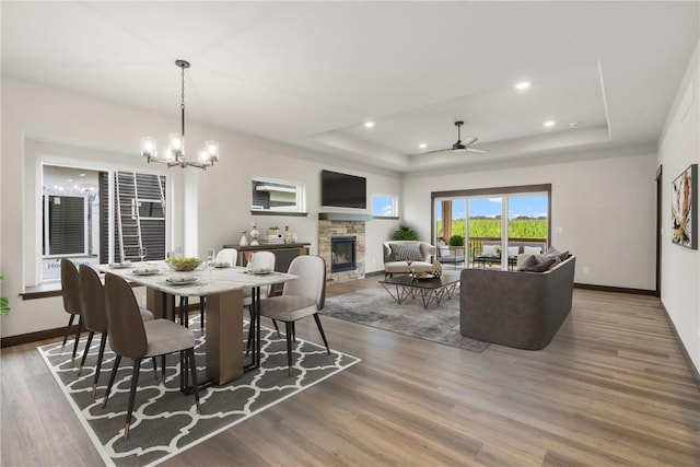 1232 Berkshire Ln, North Liberty, IA 52317 - dining space with a raised ceiling, a stone fireplace, a ceiling fan, baseboards, and recessed lighting