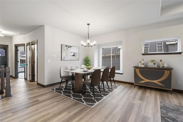 1232 Berkshire Ln, North Liberty, IA 52317 - dining area featuring light wood finished floors, a chandelier, and baseboards