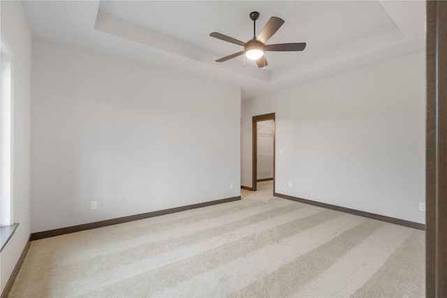 1232 Berkshire Ln, North Liberty, IA 52317 - unfurnished room featuring a tray ceiling, light colored carpet, ceiling fan, and baseboards
