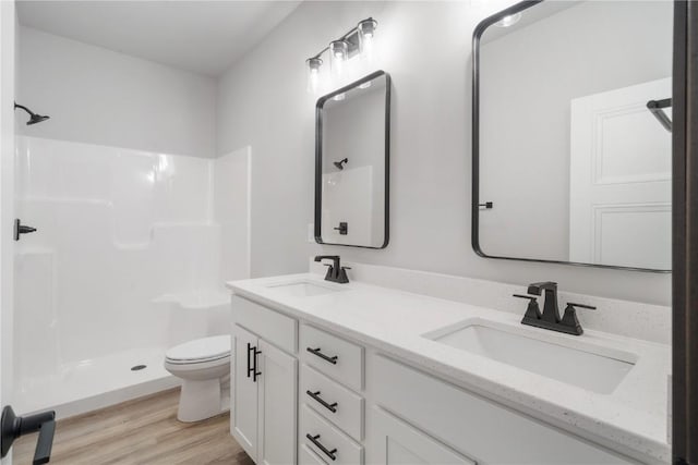 1232 Berkshire Ln, North Liberty, IA 52317 - full bathroom featuring toilet, double vanity, a shower, and wood finished floors