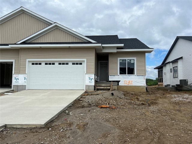 1232 Berkshire Ln, North Liberty, IA 52317 - view of front of property with concrete driveway, an attached garage, central AC unit, and a shingled roof
