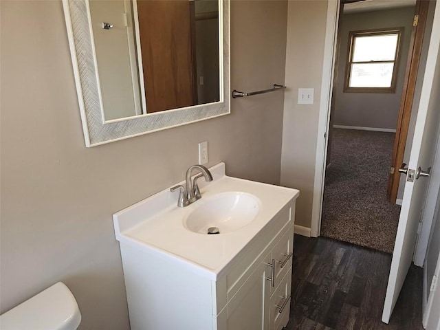 2704 Otis Rd SE, Cedar Rapids, IA 52403 - half bathroom with vanity, toilet, wood finished floors, and baseboards