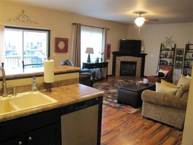 1785 Sara Ct, North Liberty, IA 52317 - living room with wood finished floors, a ceiling fan, and a tile fireplace