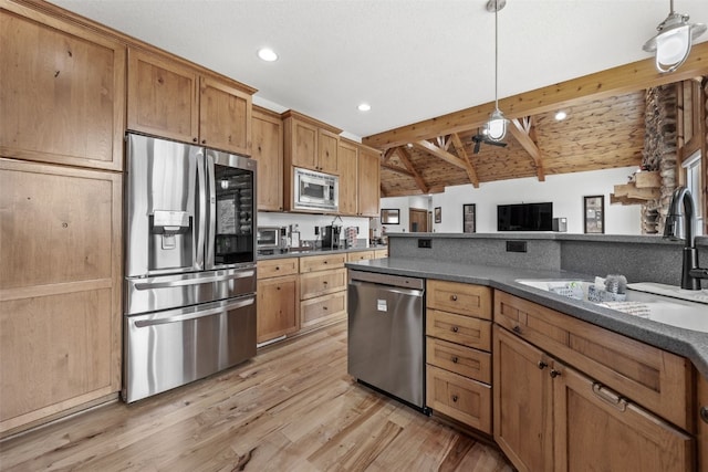 kitchen with dark countertops, lofted ceiling with beams, appliances with stainless steel finishes, and a sink