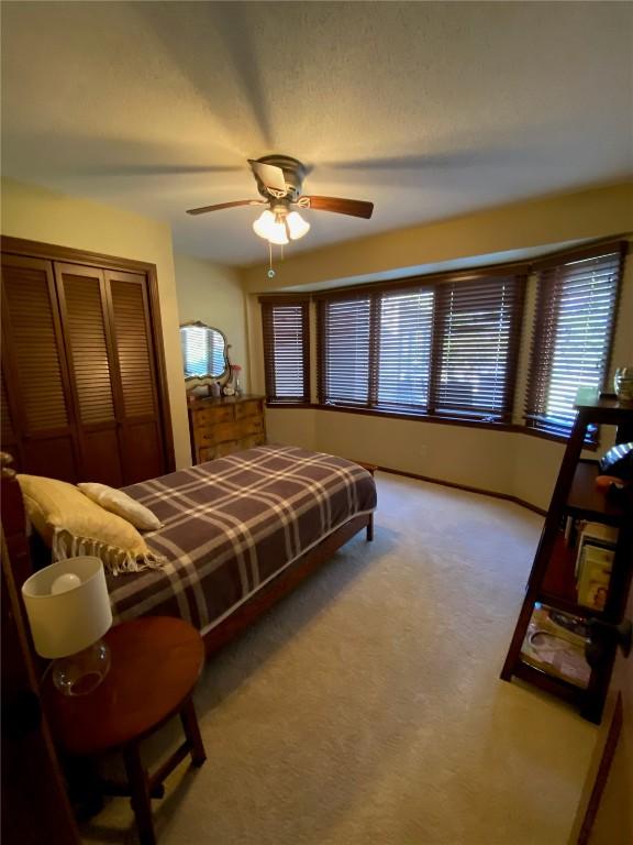 carpeted bedroom with a closet and a ceiling fan