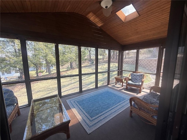sunroom / solarium featuring a ceiling fan, a skylight, lofted ceiling, and wood ceiling