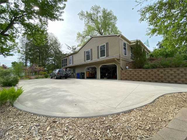 view of side of property with a garage and concrete driveway