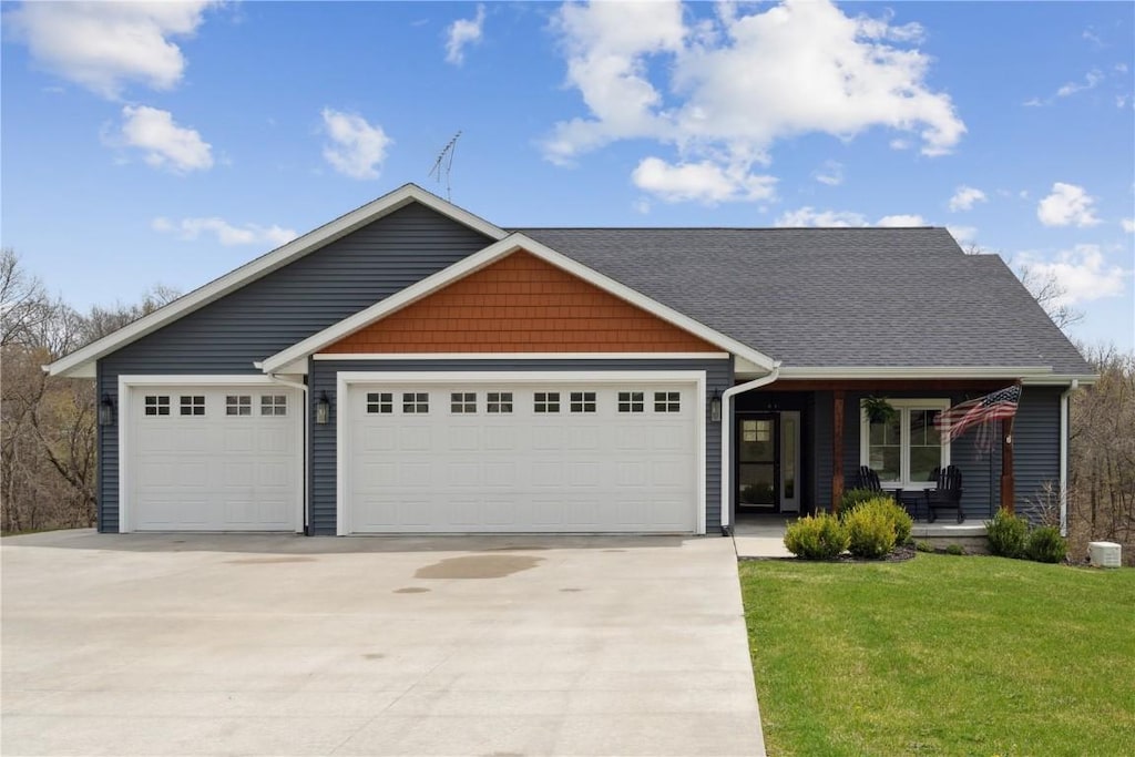 21418 Huntington Hills Dr, Anamosa, IA 52205 - craftsman-style home featuring a porch, a front yard, driveway, and a garage
