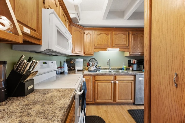 51 29th Avenue Dr SW Unit 22, Cedar Rapids, IA 52404 - kitchen with a sink, brown cabinets, white appliances, and light wood-style flooring