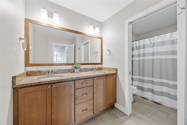 919 Camp Cardinal Rd, Iowa City, IA 52246 - full bathroom with baseboards, a sink, double vanity, and toilet