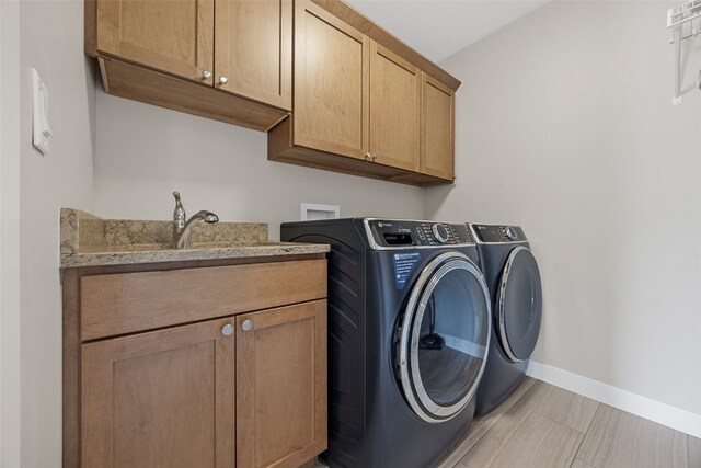 919 Camp Cardinal Rd, Iowa City, IA 52246 - washroom with separate washer and dryer, baseboards, cabinet space, and a sink