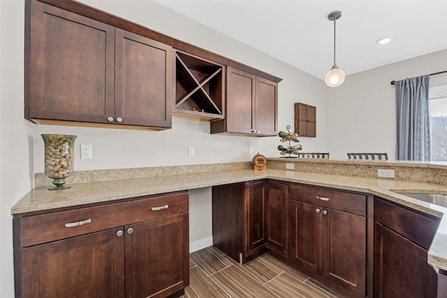 919 Camp Cardinal Rd, Iowa City, IA 52246 - kitchen featuring open shelves, light stone countertops, pendant lighting, and dark brown cabinetry