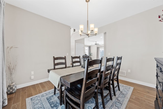919 Camp Cardinal Rd, Iowa City, IA 52246 - dining space featuring wood finished floors, visible vents, baseboards, and ceiling fan with notable chandelier