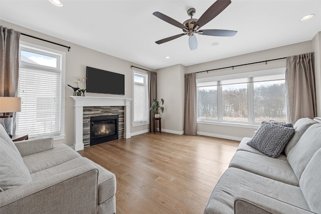 919 Camp Cardinal Rd, Iowa City, IA 52246 - living room with light wood-style flooring, ceiling fan, a tiled fireplace, baseboards, and recessed lighting