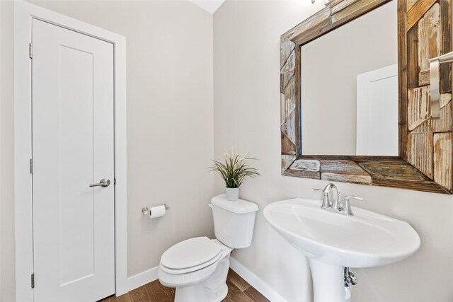 919 Camp Cardinal Rd, Iowa City, IA 52246 - half bathroom featuring wood finished floors, baseboards, a sink, and toilet